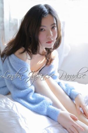 Gloria Asian Massage London Escort in blue jumper sat on the bed