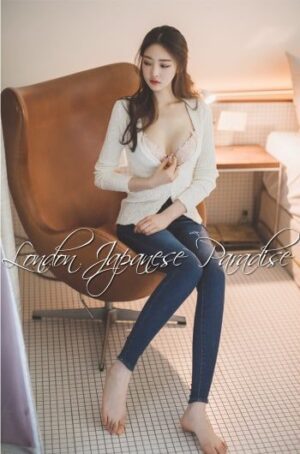 Lucy Taiwanese London Agency Escort posing on a large brown swivel chair