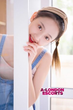 Zoe Taiwanese Mayfair Escort poses by a white post