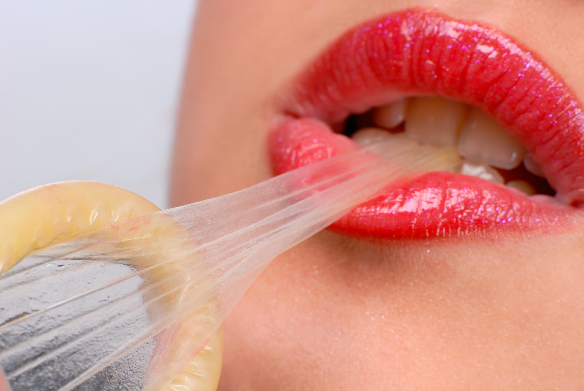 woman biting a condom