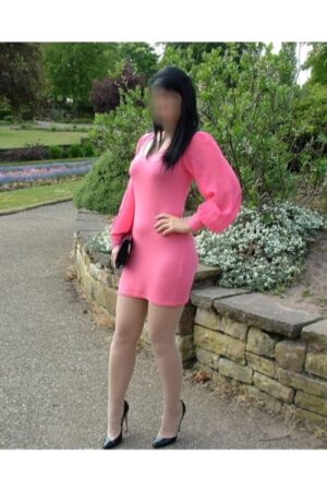 Edinburgh escort in pink dress holding purse outside