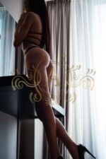 Birmingham escort with a perfect ass leaning into a hotel table