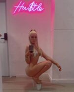sexy blonde in high heels posing with neon sign