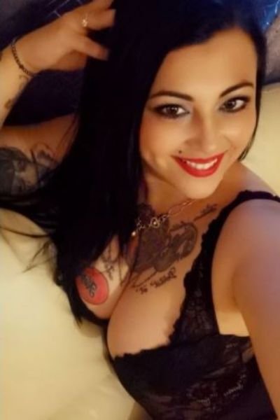 tattooed and busty raven haired escort
