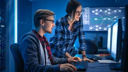 man and woman looking at computer screen