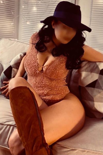 busty Swansea escort showing off cleavage in hat