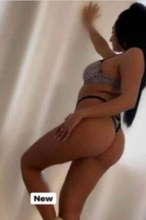 fine figured Sussex escort posing against wall