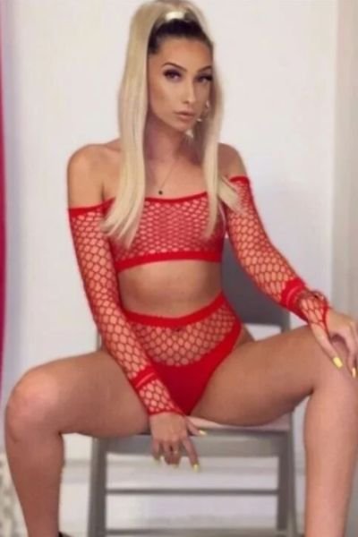 hot tanned escort in red fishnet outfit