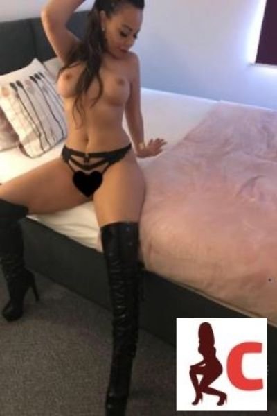 escort sitting on bed flashing tits