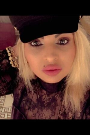 bleach blonde mature Newport escort in a hat