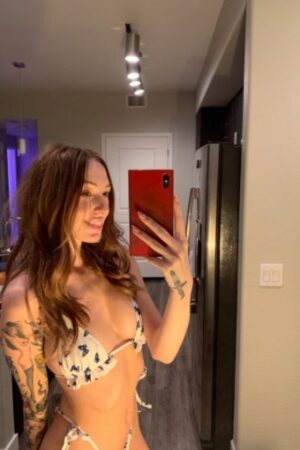 Smiling hot brunette escort takes a selfie