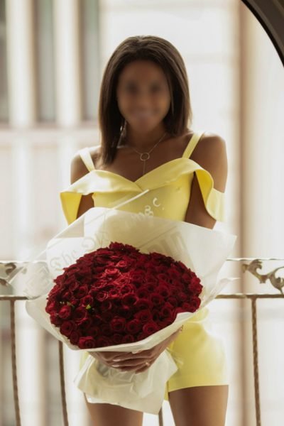 Ebony Manchester Escort holding a bouquet of roses