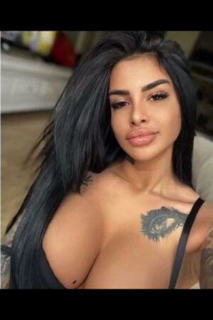 Busty Escort in Bangor shows tattoo on her big cleavage