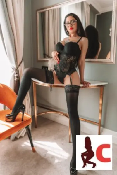 Brunette escort in glasses wearing stockings