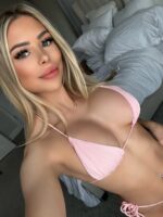 Busty young blonde escort in a pink bra