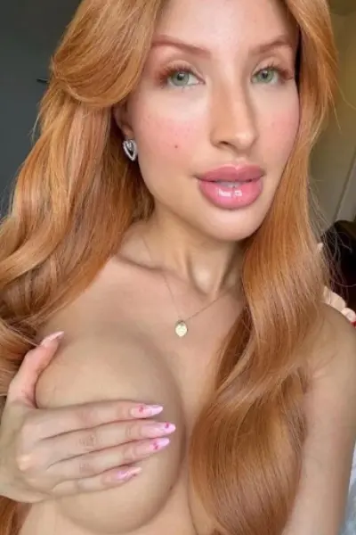 Edinburgh escort covers her breast with her hand