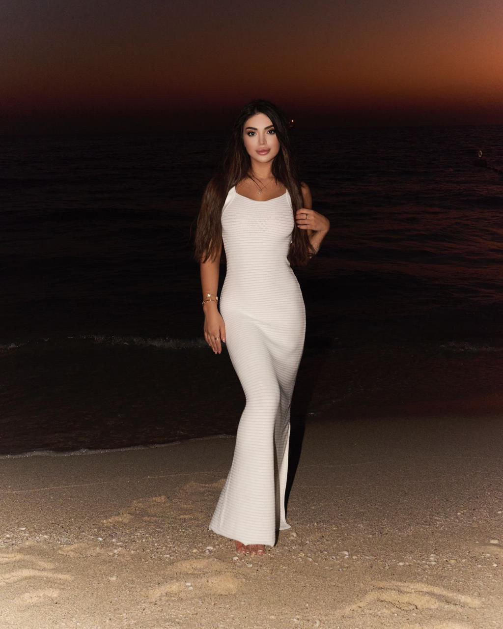 Brunette girl in white dress by the sea
