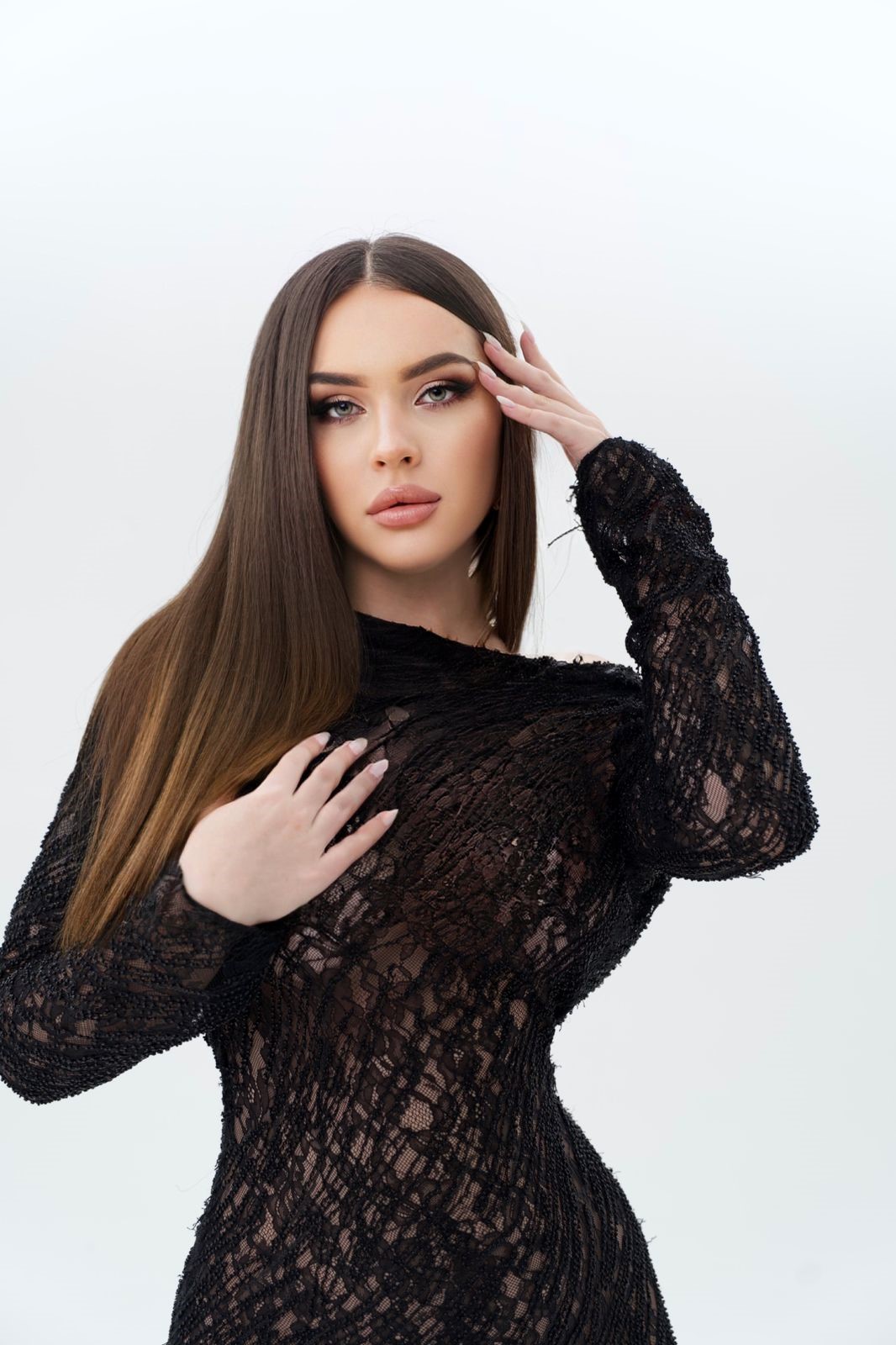 Brunette young escort in see through black dress