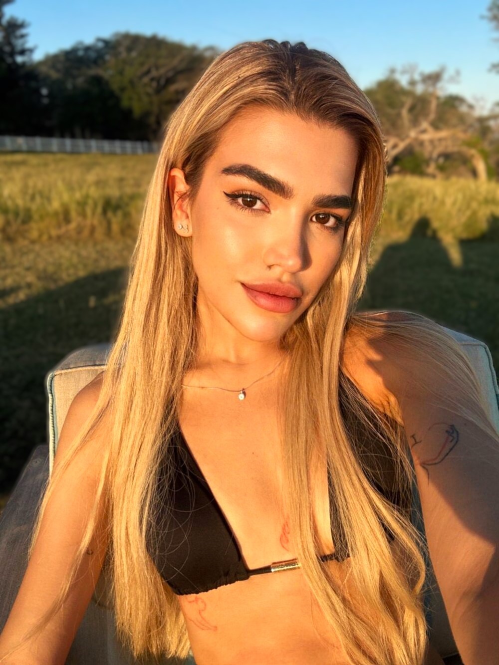 Young blonde escort in a black bikini