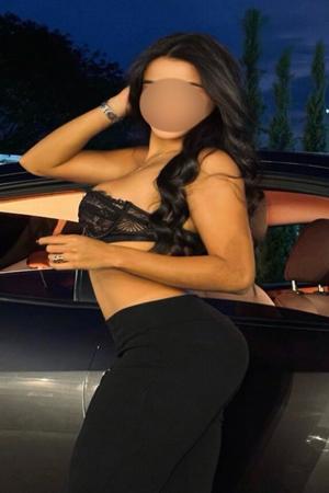 Indian Escort posing by her car