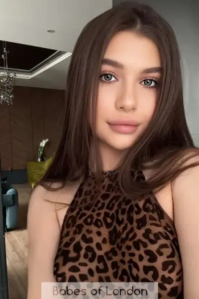 Young brunette escort in leopard print top