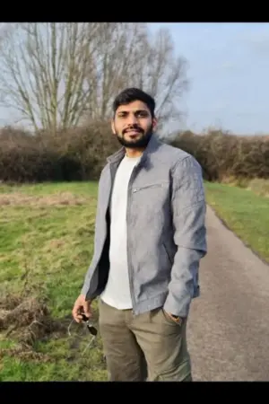 Asian male escort in grey coat holding sunglasses