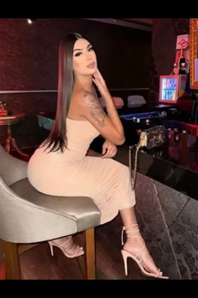 Tattooed Birmingham escort in a long beige dress