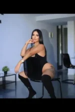 Curvy dark haired Bridgend escort straddling a chair