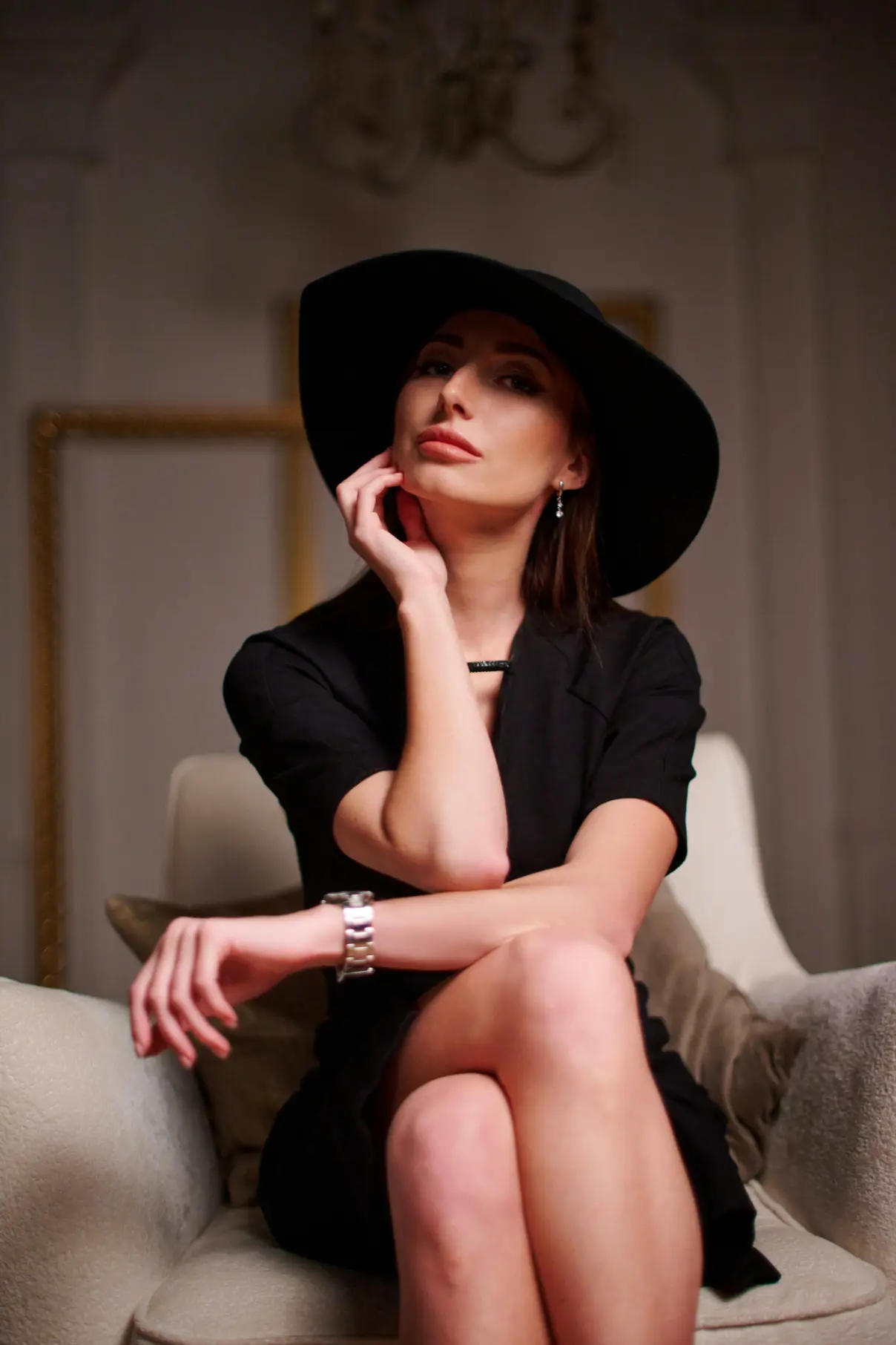 Mature escort in a black outfit and hat