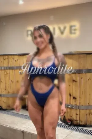 Busty tattooed escort in blue lingerie