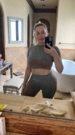 Blonde escort taking a selfie in the bathroom