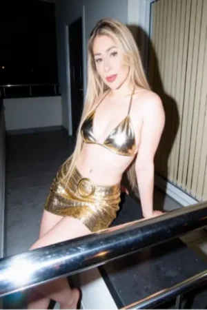 Blonde Biddenham Escort wearing a shimmering gold bikini