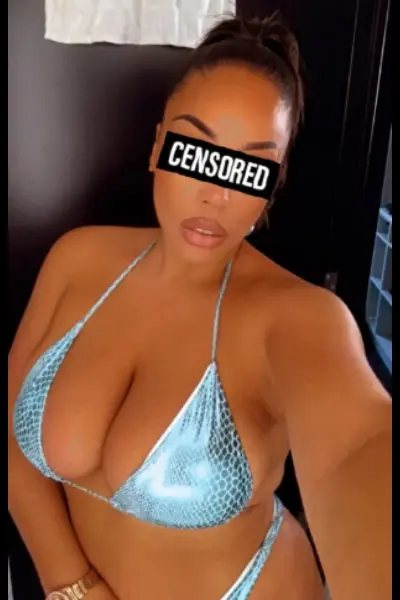 Busty mixed race escort in a blue shimmering bikini