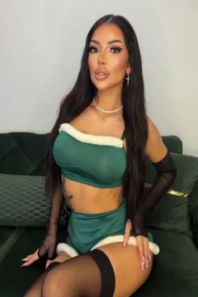 Sexy long-haired Ipswich escort in a green santa outfit