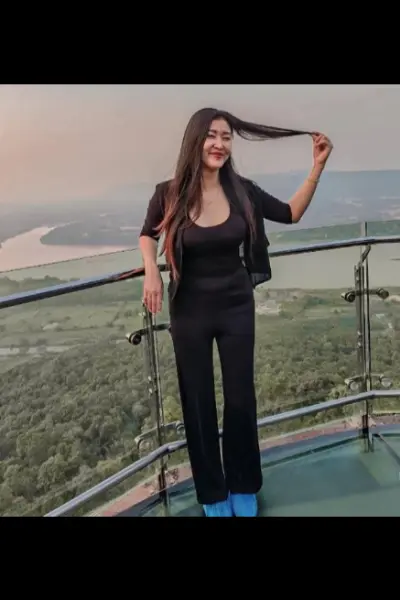 Asian escort posing on a high up balcony