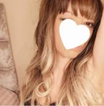 Young Newquay escort with a white love heart covering her face