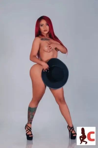 Naked coloured hair Dublin escort covering pussy with a hat