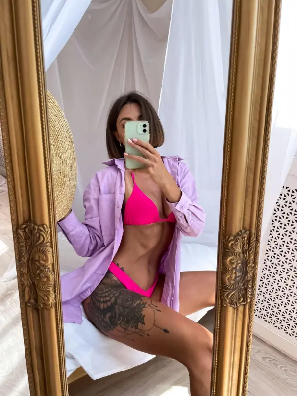 Sexy woman in a pink bikini taking a selfie
