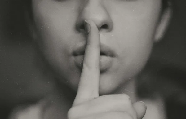 Woman with finger to her lips