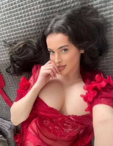 Busty Woking escort wearing a red dress
