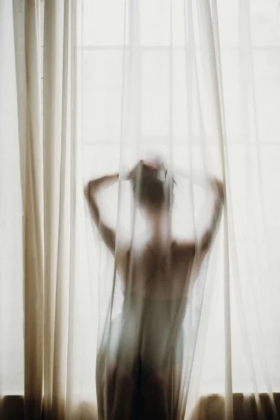Women posing behind a curtain