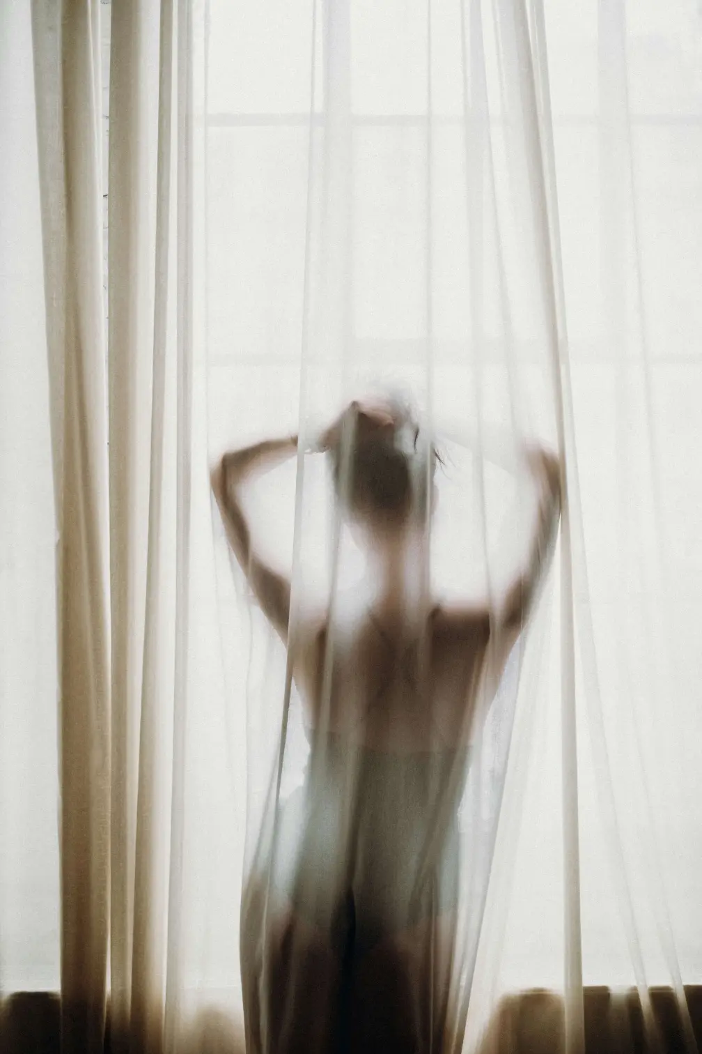 Women posing behind a curtain