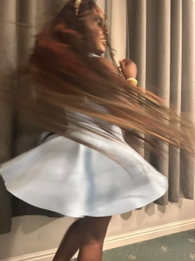 Ebony escort spinning in a dress